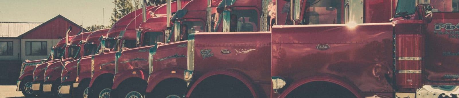 Row of highway tractors parked at a fleet terminal