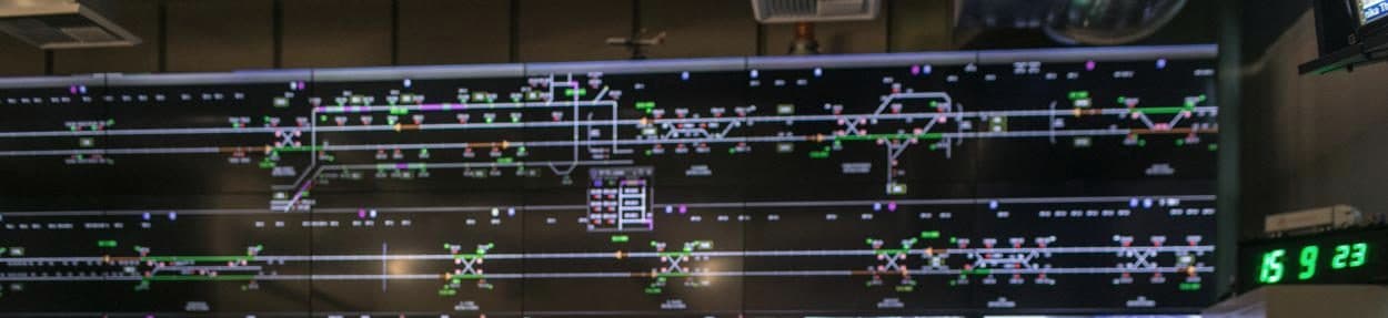 Large control-room wall displaying live operational status boards